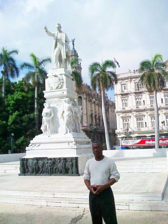 Lasana Sekou bij het beeld van José Marti in Cuba.